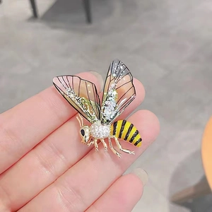 Detailed macro view of bee brooch wings and sparkling rhinestones in a hand display
