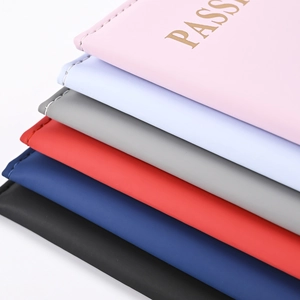 Stacked variety of smooth PU leather passport holders in pastel and classic colors
