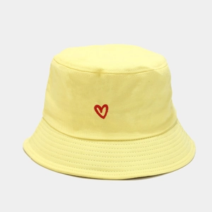 Close-up of a yellow cotton bucket hat featuring detailed red heart embroidery on the front