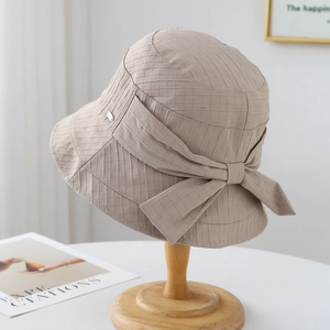 Elegante cappello a secchiello kaki da donna con fiocco su supporto in legno