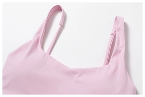 Gros plan des coutures fines sur le soutien-gorge de sport rose pâle à col en V