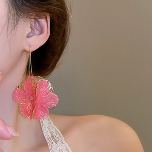Détail de boucles d'oreilles fleurs roses avec pétales en tulle et crochets dorés