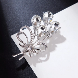 Detailed view of silver flower brooch with sparkling zircon crystals on dark background
