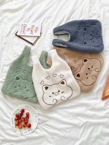 Flat lay of colorful plush teddy bear wrist bags on a white textured background