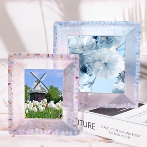 Detail of handmade resin photo frames with colorful beads on a Future book background