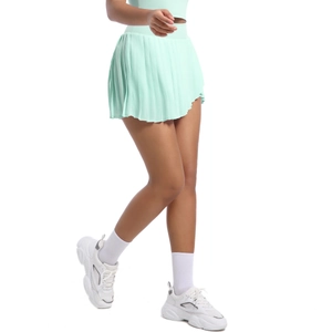 Detail of mint green pleated tennis skirt showing moisture-wicking fabric and elastic waist
