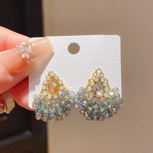 Détails de boucles d'oreilles à nœud avec perles, strass champagne et pampilles bleues