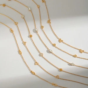Detail of 18K gold titanium steel necklaces with butterfly heart and flower charms