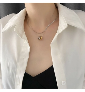 Detail of layered titanium steel necklace with gold and silver interlocking circles