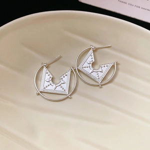Detailed view of silver geometric hoop earrings with triangular ethnic patterns