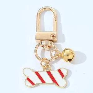 Christmas bone keychain with red striped enamel pendant and gold bell on white background
