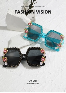 Detail of oversized square sunglasses with sparkling rhinestone embellishments and floral accents