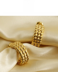 Detail of gold C-shape twisted earrings with 18K vacuum plating on satin silk background