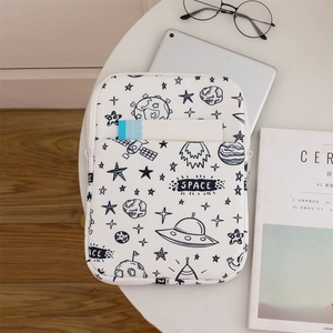 Close-up of white padded laptop sleeve featuring black space-themed hand-drawn patterns