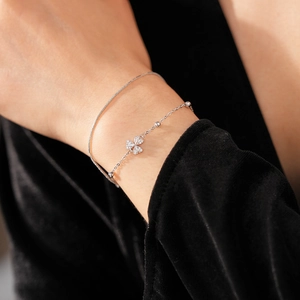 Makroaufnahme eines silbernen doppelreihigen Kleeblatt-Armbands mit funkelnden Zirkonia