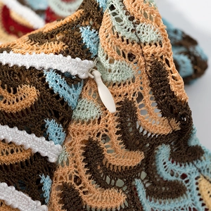 Gros plan sur un tricot au crochet bohème avec motifs colorés et fermeture éclair cachée