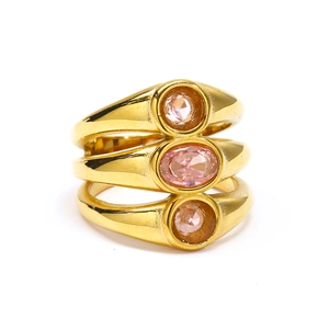 Detail of triple-layer gold ring featuring three oval-cut pink zircon stones