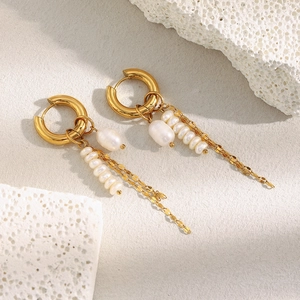 Close-up of 18K gold plated chain earrings with baroque pearls on stone decor