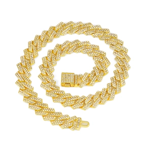 Macro detail of 15mm gold-plated Cuban link chain with encrusted diamonds on white background