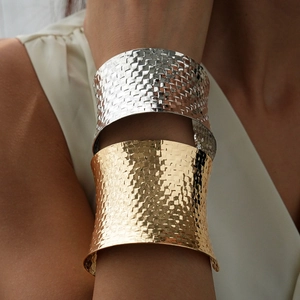 Detail of wide woven texture metal open cuff bracelet in gold and silver finish