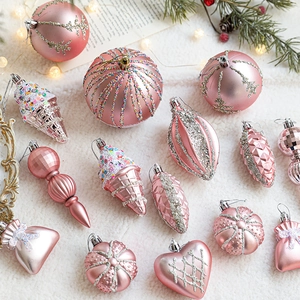 Pink Christmas ball ornament set with star and heart shapes on white plush background