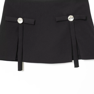 Mini-jupe noire avec rubans à nœuds élégants et boutons en strass étincelants sur fond blanc