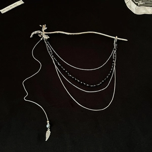 Épingle à cheveux argentée design dragon avec pampilles de feuilles sur fond noir