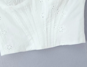 Détail du tissu en dentelle blanche avec broderie anglaise et volants texturés élégants