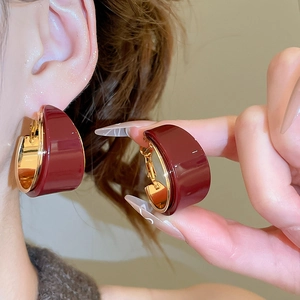 Détail des boucles d'oreilles en résine bordeaux avec doublure en plaqué or 18 carats