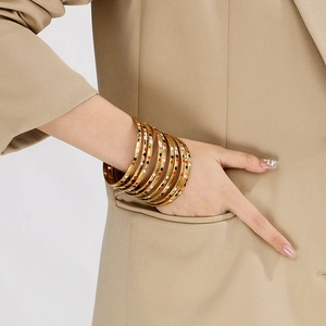 Detailed view of stacked 18K gold-plated stainless steel bangles with colorful heart patterns