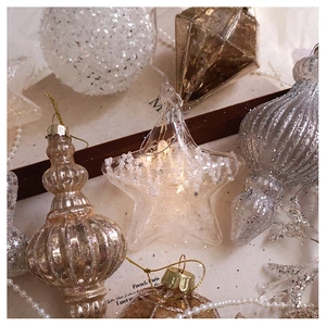 Macro detail of silver snowflake Christmas ball ornaments with warm LED fairy lights