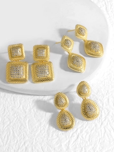 Detalle macro de pendientes geométricos dorados con pavé de circonitas cúbicas