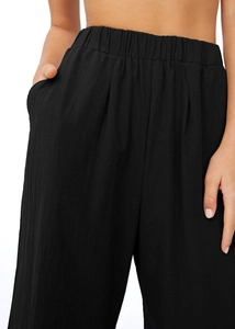 Détail de la taille élastique haute et de la poche latérale sur le pantalon noir en lin