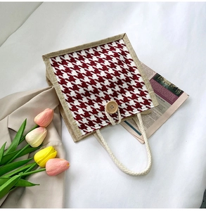Detail of red houndstooth canvas tote bag with wooden button and cotton rope handles