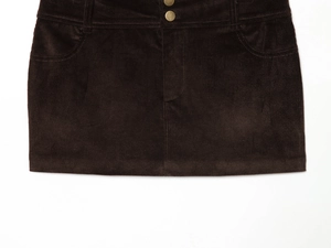 Detailed view of dark brown corduroy mini skirt showing waist buttons and fabric texture