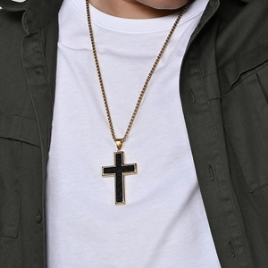 Large titanium steel cross necklace with black textured inlay and gold edges on model