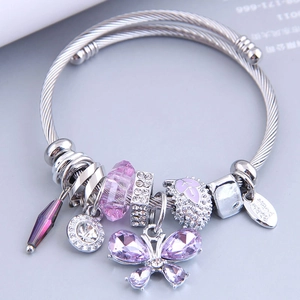 Bracelet jonc argenté avec breloques papillon violettes et perles en cristal sur gris