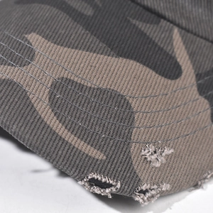 Détail macro d'une casquette de baseball camouflage avec bords usés et coutures renforcées