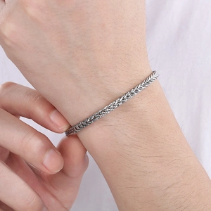 Nahaufnahme eines silbernen Drachenknochen-Kettenarmbands aus Edelstahl am Handgelenk