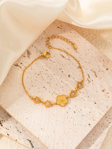 Detailed macro view of a gold floral bracelet with sparkling zircons on a silk backdrop