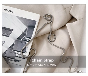 Macro detail of a high-quality silver snake bone metal chain strap on a cream blazer