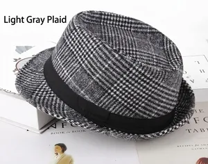 Détail d'un chapeau fedora gris à carreaux avec ruban noir sur un décor de livres anciens