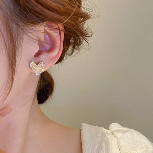 Close-up of heart-shaped crystal stud earrings worn on model for a sparkling elegant look