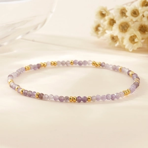 Bohemian style thin purple amethyst beaded bracelet with gold accents on white background