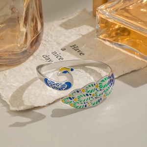 Detailed macro view of peacock enamel open bangle in silver finish with vibrant colors
