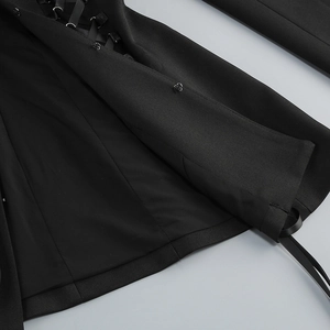 Macro shot of side drawstring ties and metallic eyelets on the black blazer dress