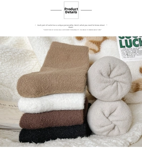 Close-up of thick thermal winter socks in brown, black, and grey on a soft rug