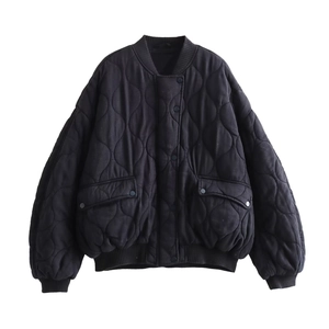 Détail de la veste bomber noire matelassée avec boutons-pression et poches cargo