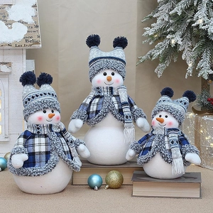 Set di tre pupazzi di neve in peluche blu e bianchi su libri vintage per decoro Natale