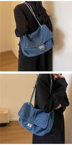 Detail of vintage blue denim chain bag featuring silver twist lock and woven metal strap